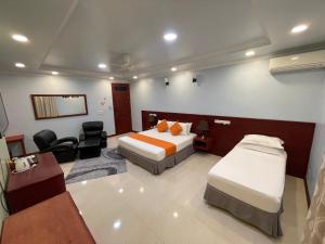 a hotel room with two beds and a desk at Vista Villa in Hithadhoo
