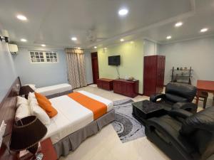 una camera con letto, sedia e televisore di Vista Villa a Hithadhoo