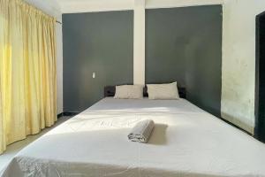 um quarto com uma grande cama branca com uma toalha em 711 Gili Trawangan Mitra RedDoorz em Gili Meno