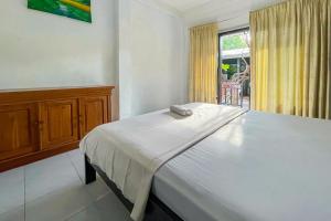 a white bed in a room with a window at 711 Gili Trawangan in Gili Meno