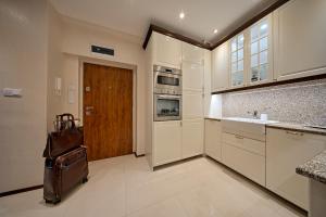 eine Küche mit weißen Schränken und einer braunen Tür in der Unterkunft Villa la Val, Apartamenty Wałbrzych in Wałbrzych