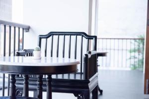 a table and chairs with a potted plant on a porch at The Lantern Hatyai Hotel in Hat Yai