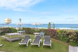 a group of chairs and a table and umbrella at Surfers International Apartments in Gold Coast