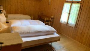 a room with two beds in a wooden cabin at Berghaus Iffigenalp in Lenk