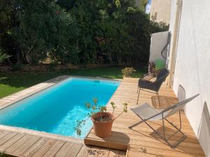 una terraza con una silla y una piscina en Maison pieds dans l eau avec piscine et clim en Linguizzetta