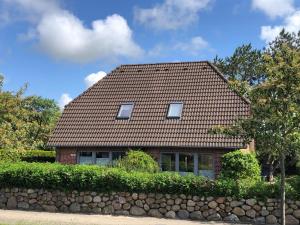 a red brick house with a stone wall at Ferienhaus SPO 54 grad in Böhl
