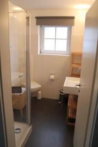 a bathroom with a sink and a toilet and a window at Ferienhaus SPO 54 grad in Sankt Peter-Ording