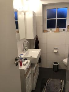 a white bathroom with a sink and a mirror at Ferienhaus SPO 54 grad in Sankt Peter-Ording +38 photos