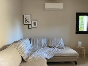 ein Sofa mit einer Decke darauf im Wohnzimmer in der Unterkunft Maison pieds dans l eau avec piscine et clim in Linguizzetta + 29 Fotos