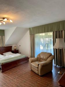 a bedroom with a bed and a couch and a chair at Pension Casa Iurca in Sighetu Marmaţiei