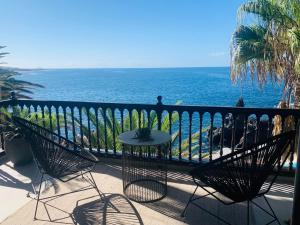 balkon ze stołem i krzesłami oraz oceanem w obiekcie 3 bedroom ocean shore apartment w mieście Puerto de Santiago