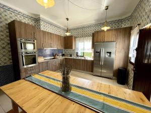 a kitchen with a wooden table and a refrigerator at Villa OceanKokia in Albufeira