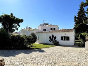 a white house with a cobblestone driveway at Villa OceanKokia in Albufeira