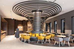 a restaurant with yellow chairs and a large ceiling at Ikonik Lisboa in Lisbon