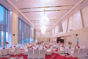 a large banquet hall with white tables and white chairs at Holiday Inn Shanghai Hongqiao West, an IHG Hotel in Qingpu