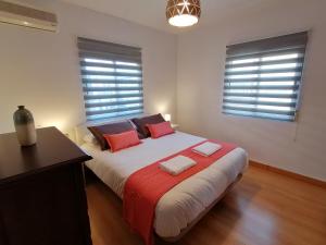 a bedroom with a large bed with red pillows at Spacious Apartment in Armilla