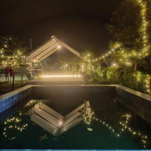 basen z oświetleniem w ogrodzie w nocy w obiekcie H7Stay Luxury Cottages And Camps, Rishikesh w mieście Rishikesh