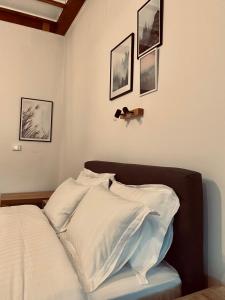 a bedroom with a bed with white sheets and pictures on the wall at 11 Luxury Apartments Metsovo in Metsovo