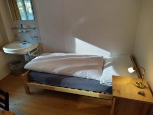 una piccola camera con letto e lavandino di Gasthaus Meinradsberg a Einsiedeln Altre 24 foto