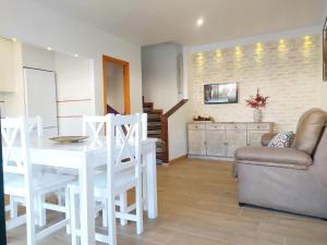 een woonkamer met een witte tafel en stoelen bij Gran adosado de esquina muy cerca de la playa en la Antilla in Huelva