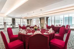 una sala conferenze con tavoli, sedie rosse e finestre di Radisson Blu Hotel, Doha a Doha Altre 37 foto
