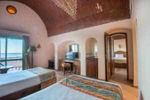 a bedroom with two beds and a view of the ocean at Shams Alam Beach Resort in Abū Ghuşūn