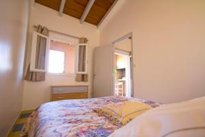 a bedroom with a bed and two windows at Résidence Colombara in Cargèse