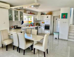 a kitchen with a table and chairs and a refrigerator at Ahla Plus in Eilat
