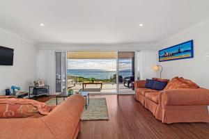 a living room with two couches and a view of the ocean at Blue Bay Beach Stay - Mandurah in Mandurah