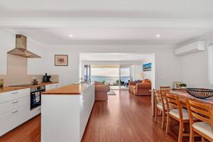 a kitchen and living room with a table and chairs at Blue Bay Beach Stay - Mandurah in Mandurah