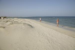 a group of people walking on the beach at Shams Alam Beach Resort in Abū Ghuşūn