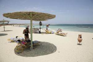 a group of people sitting on the beach at Shams Alam Beach Resort in Abū Ghuşūn