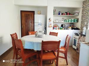 a kitchen with a table with chairs and a refrigerator at Casas Bérgamo in Morro de São Paulo