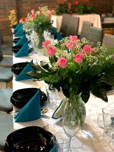 a long table with pink roses in a vase at MARINASURF Baza Wypoczynkowa in Przeczyce