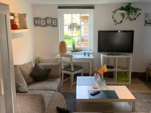 a living room with a couch and a tv at Ferienwohnung Schmidt in Rosengarten