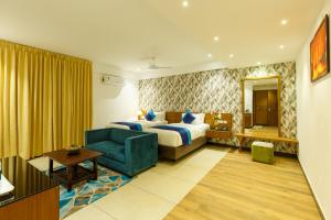 um quarto de hotel com uma cama e uma cadeira azul em Royal Ace Boutique Hotel em Bangalore
