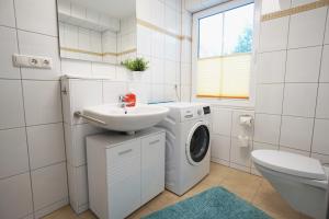 班辛海的住宿－Duenenresidenz Bansin，一间带洗衣机和水槽的浴室