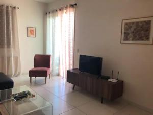a living room with a flat screen tv and a chair at Klimentos Flat 58 in Nicosia
