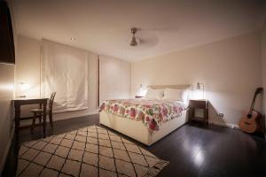 a bedroom with a bed and a table and a guitar at Gumtree Glen in Kangaroo Valley