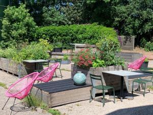 a group of pink chairs and a table in a garden at Het Lage Noorden in Marrum