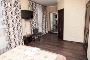 Habitación de hotel con cama y TV en la pared en Chyhorinskyi Hotel en Kiev