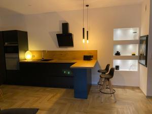 a kitchen with a blue island with two bar stools at Chjama di mare in Santa-Maria-di-Lota