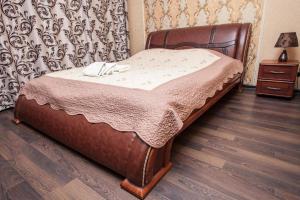 Cama de madera en habitación con suelo de madera en Chyhorinskyi Hotel en Kiev