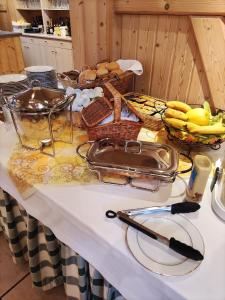 a table with glasses and baskets of bananas on it at Hotel-Pension Flechsig in Hartmannsdorf
