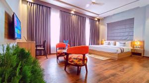 ein Hotelzimmer mit einem Bett, einem Tisch und Stühlen in der Unterkunft ShriGo Hotel Nathdwara in Nāthdwāra