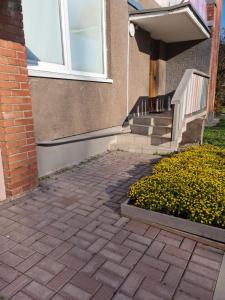 a brick walkway in front of a house with stairs at Vėtrungės Apartamentai in Klaipėda
