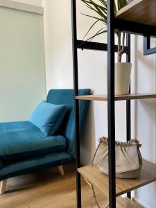 un sofá azul y una silla en una habitación en Galilei Apartment en Merano