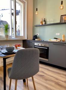kuchnia ze stołem, krzesłem, stołem i kuchenką w obiekcie Galilei Apartment w Meranie