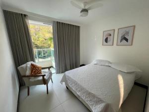 una camera con un letto e una sedia e una finestra di Apartamento em Santa Teresa a Santa Teresa