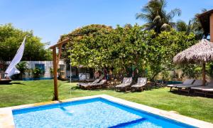 a swimming pool in the yard of a house at Pousada & Food 3 Abelhas in Cumbuco